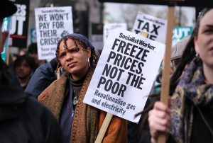 A protester opposite Downing Street listens to one of the speakers on a day of action over the surging cost of living. 