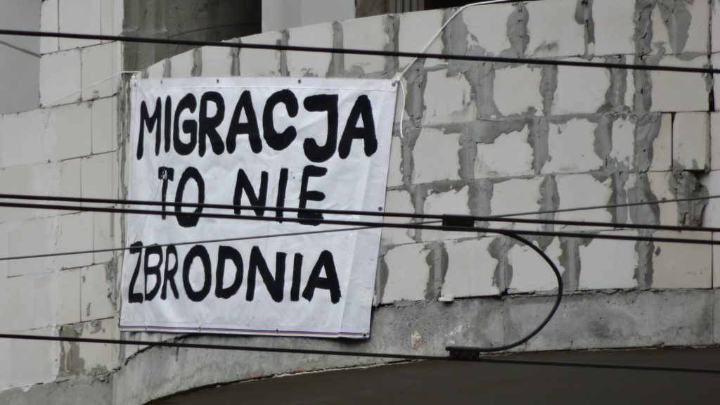 "Migration is not a crime" written in Polish on a sheet in the street (Photo: yesfuture / Flickr.com)