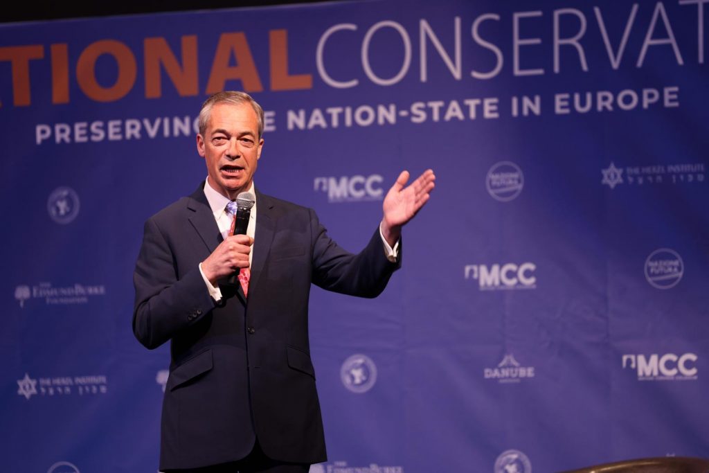 British politician Nigel Farage on stage at the NatCon Brussels 2 conference in Brussels, April 16, 2024 (Photo: NatConTalk / X.com)